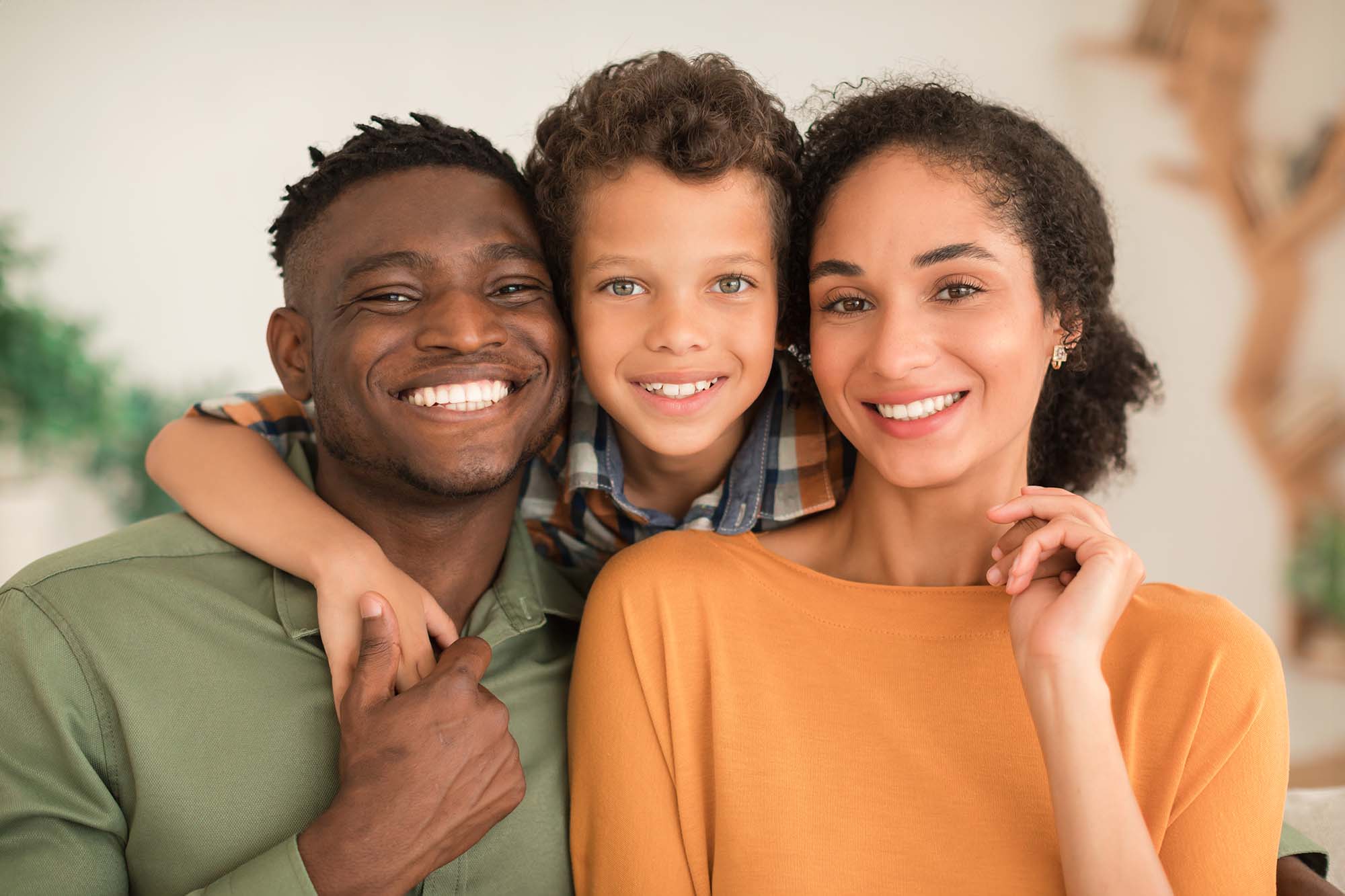 cheerful-diverse-parents-and-kid-son-hugging-at-ho-2023-11-27-05-01-06-utc.jpg